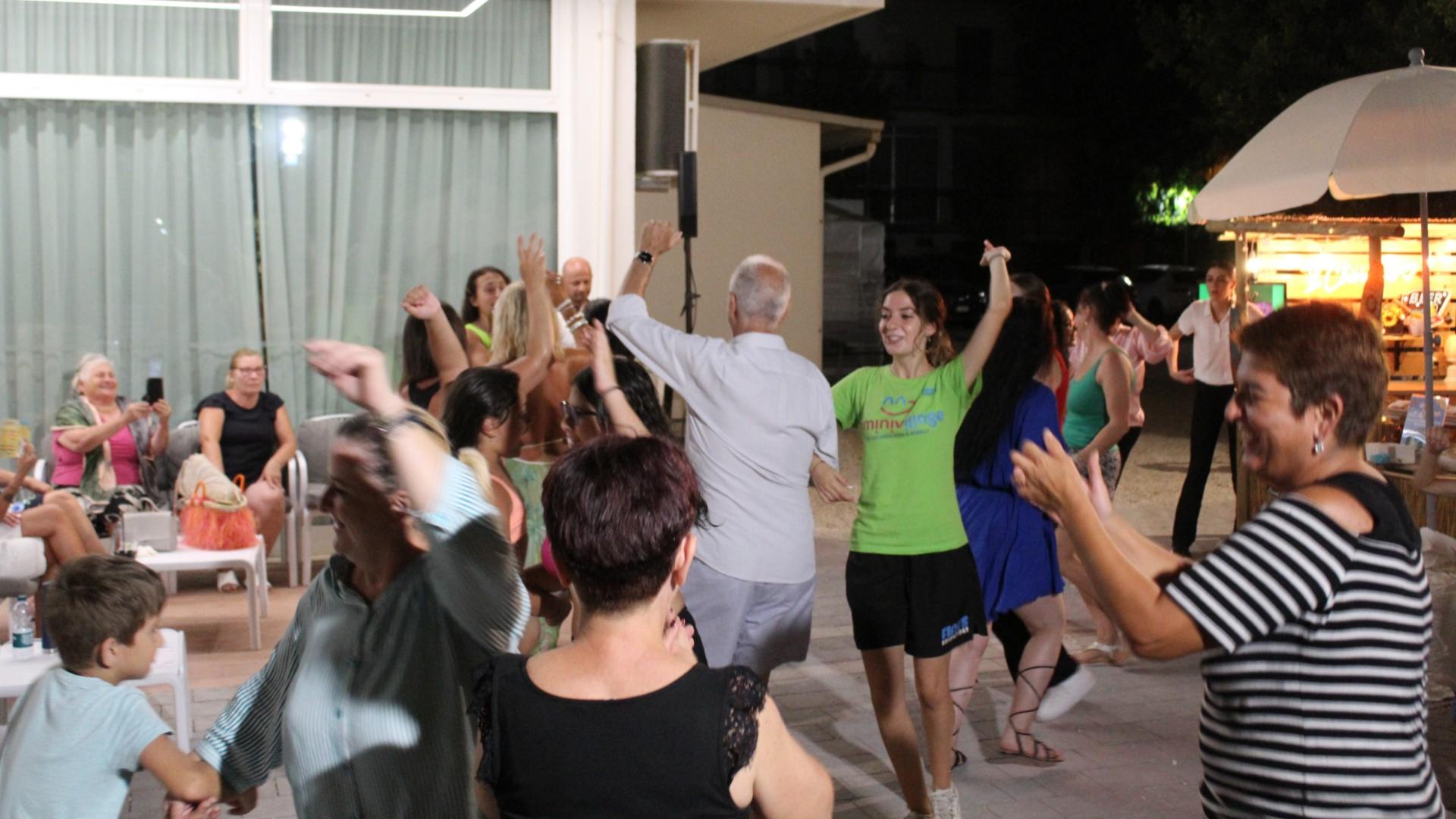 Persone ballano e si divertono all'aperto durante una serata estiva.