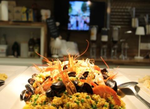 Piatto di paella con gamberi e cozze in un ristorante.