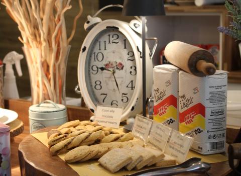 Biscotti su tavola rustica, con orologio vintage e farina in esposizione.