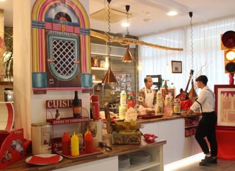 Ristorante stile diner americano con decorazioni vintage e personale al bancone.