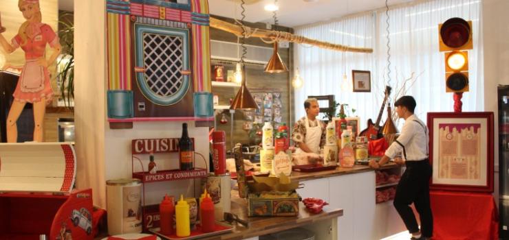 Ristorante in stile retrò con decorazioni vintage e personale al bancone.