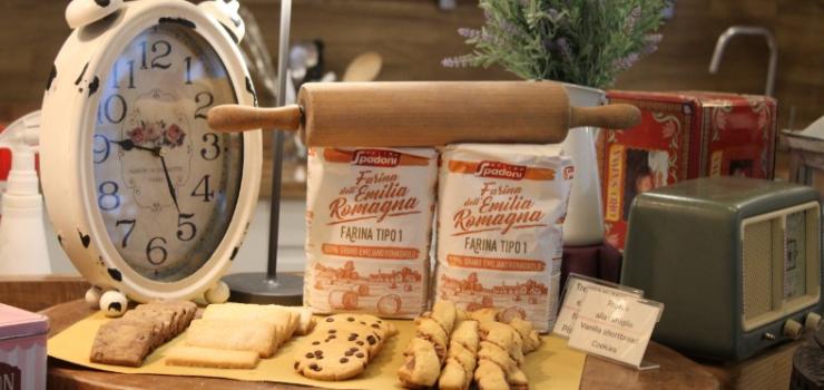 Display di farina, biscotti e un orologio vintage con mattarello.